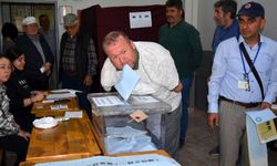 Kolları olmayan seçmen, oyunu kullanıp zarfı ağzıyla sandığa attı