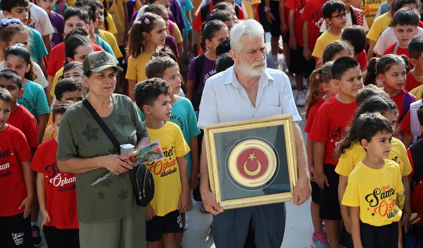 Şehit anne ve babası Türk bayrağıyla okulda
